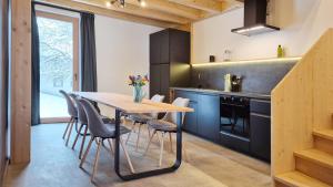 a kitchen with a wooden table and chairs at Haus am FELS, Alpenaster in Hermagor