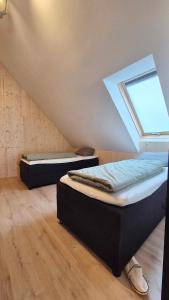 two beds in a room with a window at Haus am FELS, Alpenaster in Hermagor