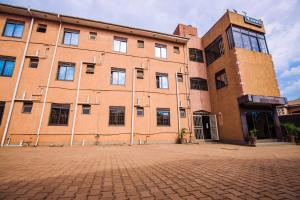 a large brick building on a brick street at Hulcity silver hotel in Kyebando