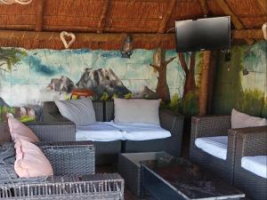 a room with wicker chairs and a wall with a mural at Petra Lodge in Edenvale