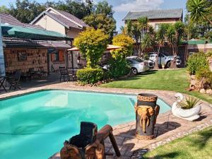 a swimming pool in front of a house at Petra Lodge in Edenvale