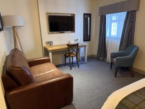 a living room with a couch and a desk in a hotel room at Red Lion Hotel by Greene King Inns in Fareham