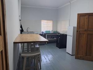 a kitchen with a wooden table and a refrigerator at Eenvoud in Rosendal