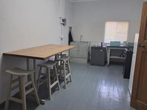 a kitchen with a wooden table and stools at Eenvoud in Rosendal +16 photos