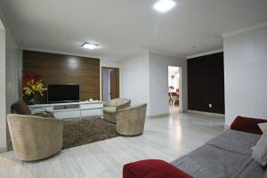 a living room with a couch and chairs and a television at Casa com Piscina e Churrasqueira em Taguatinga in Taguatinga