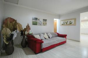 a living room with a red couch and two vases at Casa com Piscina e Churrasqueira em Taguatinga in Taguatinga +38 photos