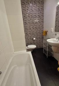 a bathroom with a tub and a sink and a toilet at Oasis Apartment in Sliema
