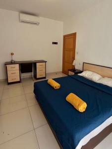 a bedroom with a bed with two yellow pillows on it at Oasis Apartment in Sliema