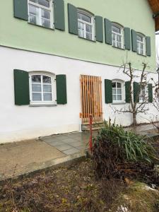 a house with green shutters and a wooden door at Ferienhaus Winterbach - Alte Käserei in Winterbach