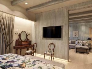 a bedroom with a bed and a tv on a wall at Semeli Estate Suites in Koútsion