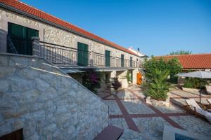 a stone building with a balcony and a patio at Villa Dvori Jokic in Islam Grčki