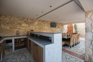 a large kitchen with a stone wall and a table at Villa Dvori Jokic in Islam Grčki