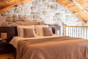 a bedroom with a large bed in a stone wall at Villa Dvori Jokic in Islam Grčki +44 photos