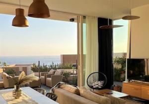 a living room with a couch and a large window at Vila Mara in Dhërmi