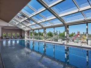 a swimming pool with a large glass ceiling and windows at Amadria Exclusive Beach Villa in Šibenik