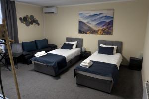 a hotel room with two beds and a couch at SergJuli Villa in Plavecký Štvrtok