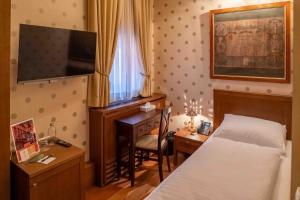 a hotel room with a bed and a desk and a television at Hotel Ptuj in Ptuj