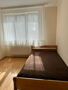 a bedroom with a bed in front of a window at Садиба Villa Bella in Velyatyn