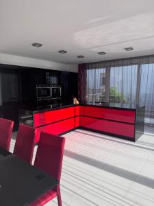 a kitchen with red cabinets and a table and chairs at Sea Whisper Villa in Dobra Voda