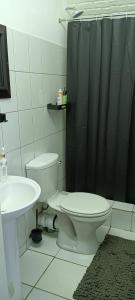 a bathroom with a toilet and a black shower curtain at Meltz Inn in Klerksdorp +8 photos