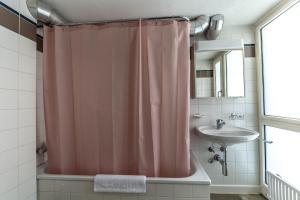 a bathroom with a pink shower curtain and a sink at Exclusive Loft in Seefeld - Mühle in Zurich