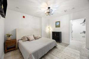 a white bedroom with a bed and a chandelier at Park Hotel 1BR Suite 210 in Chattanooga