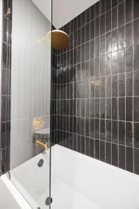 a bathroom with a black tiled wall and a shower at Park Hotel 1BR Suite 210 in Chattanooga +12 photos