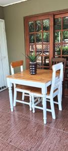 a wooden table with two chairs and a potted plant at Meltz Inn in Klerksdorp