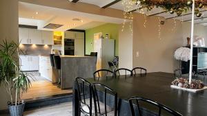 a kitchen and dining room with a black table and chairs at Mossefat in Sprimont +15 photos