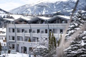 a large white building in the snow with a mountain at Anett hotel in Vipiteno