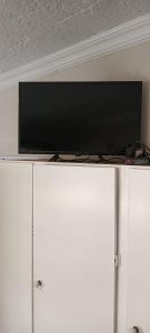 a flat screen tv on top of a white cabinet at Meltz Inn in Klerksdorp
