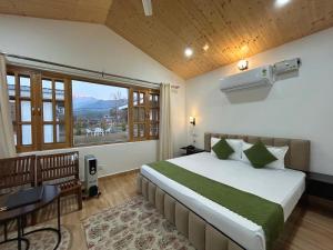 a bedroom with a bed and a large window at Saanjh Cottages - Hotel in Bir Billing in Bīr