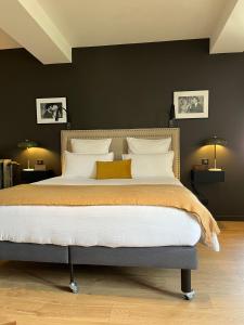 a bedroom with a large bed with white pillows at L'Hotel Particulier in Louhans