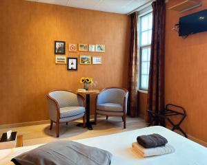 a room with a table and two chairs and a window at Radici in Nieuwpoort