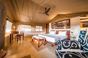 a bedroom with a bed and a table and chairs at Kudu Safari Camp in Koito