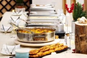 a buffet with several trays of food on a table at Pirin Sense Apartment Complex in Bansko +161 photos