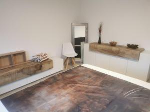 a living room with a wooden floor and a mirror at Ferienwohnung Im Auricher Tal in Vaihingen an der Enz