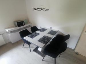 a dining room with a white table and black chairs at Ferienwohnung Im Auricher Tal in Vaihingen an der Enz