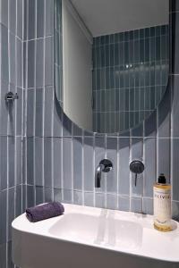 a bathroom with a sink and a mirror at Twinn Downtown Piraeus, Santikos Collection in Piraeus +31 photos