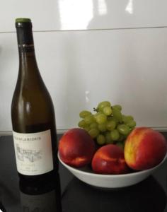 a bottle of wine next to a bowl of fruit at Nice relaxing apartment in Mandria, in Mandria