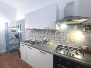 a kitchen with white cabinets and a sink and a stove at Bilocale zona Testaccio in Rome