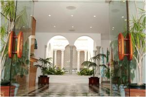 a lobby with palm trees in a building at Brasilia in Chipiona +30 photos