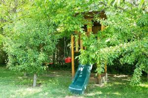 a playground with a green slide in a tree at Villa Old Almond in Balatonalmádi