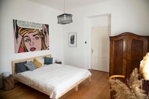 a bedroom with a bed and a painting on the wall at Villa Old Almond in Balatonalmádi