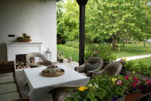 a patio with a table and chairs and flowers at Villa Old Almond in Balatonalmádi