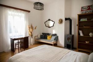a bedroom with a bed and a couch and a window at Villa Old Almond in Balatonalmádi