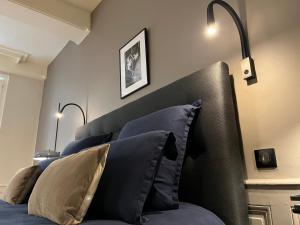 a bedroom with a bed with blue pillows at L'Hotel Particulier in Louhans