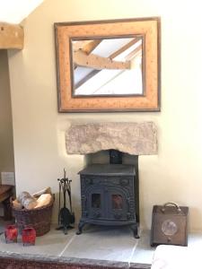 a wood stove in a room with a mirror at Moorgarth Hall Apartment, Ingleton, Yorkshire Dales in Ingleton +24 photos