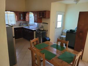 a kitchen with a wooden table and a dining room at Tropical Breeze Grenada in Westerhall Land Settlement
