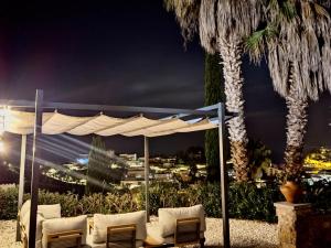 a gazebo with chairs and a palm tree at night at EVH-113 Casa Martina in Tossa de Mar